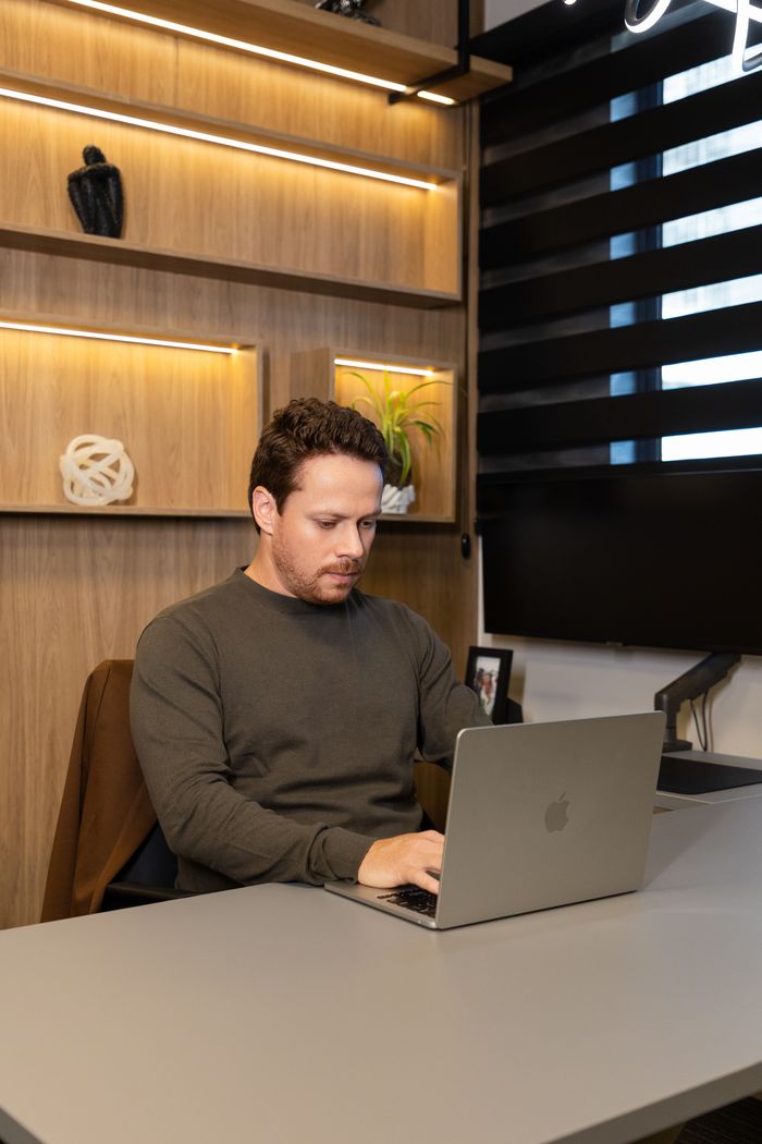 André trabalhando no notebook em sua mesa