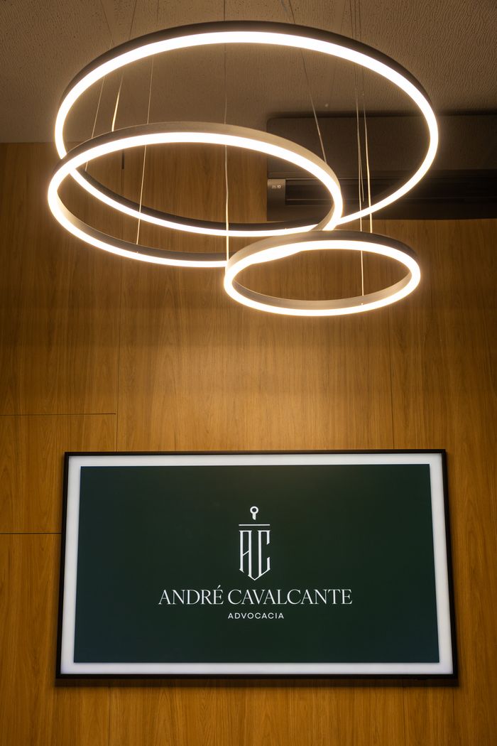 Sala de reuniões, com a marca do escritório na tela e luminárias circulares