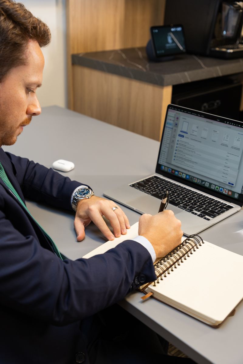 Detalhe de anotações em caderno, ao lado do notebook